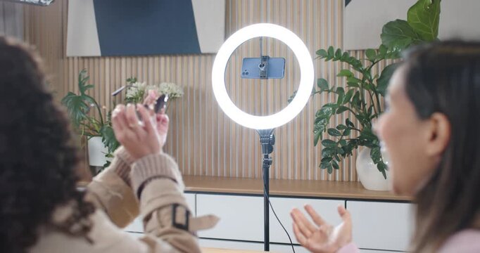 Diverse female hosts lifting shades from box showing and checking in studio with ringlight for demo