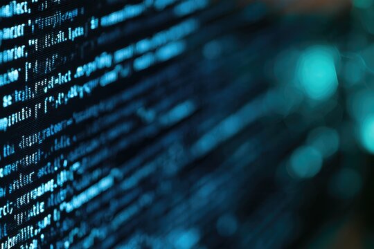 Close-up of blue computer code on a black screen with a blurred background, highlighting programming and software development.