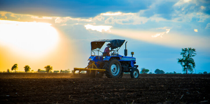 farmer with tractor preparing land for sowing with cultivator