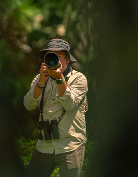 Wildlife photographer observing nature with telephoto lens