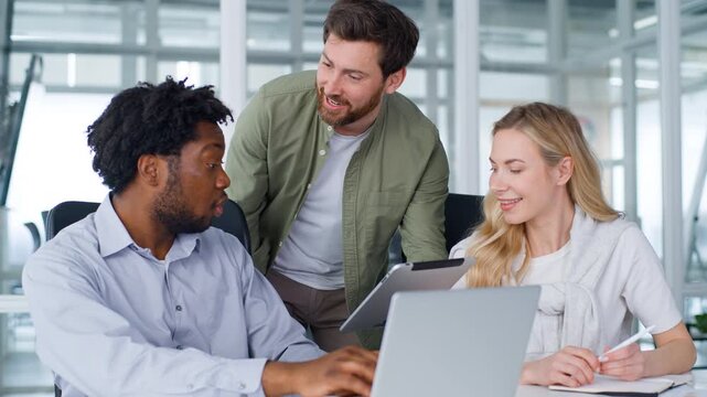Team three multiracial business managers happy talking with digital tablet excellent good result giving high five cooperation achievement work Caucasian woman with African men talk celebrate in office