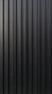 Dark ribbed steel cladding in vertical lines, matte black abstract metal background