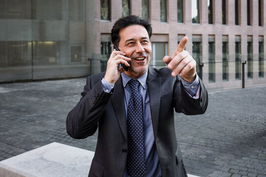 hispanic adult man talking by phone in a morning outdoors at street city