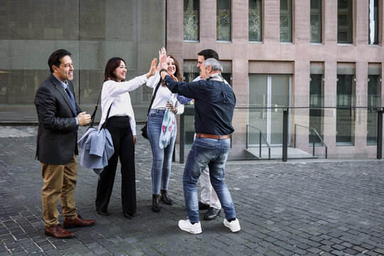 hispanic successful business adult teamwork with different ages walking together in a winter morning outdoors at street city. Diverse latino middle aged Entrepreneurs and multigenerational teamwork