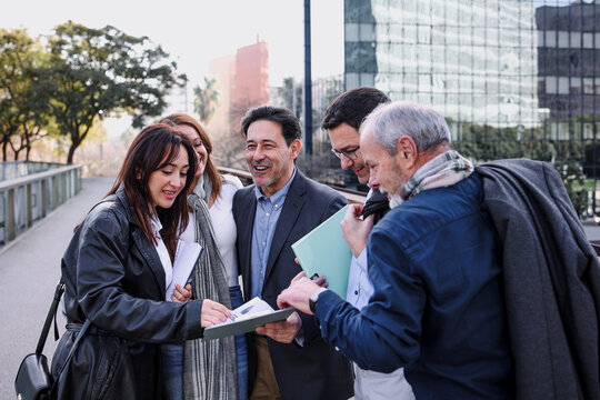hispanic successful business adult teamwork with different ages walking together in a winter morning outdoors at street city. Diverse latino middle aged Entrepreneurs and multigenerational teamwork