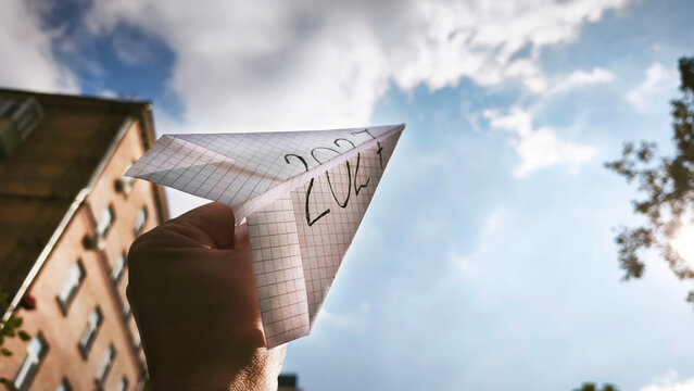 A paper airplane bearing the inscription 2027 is launched toward a bright sky, symbolizing the future, new opportunities, ambitions, innovation, dreams, and plans for the year ahead.
