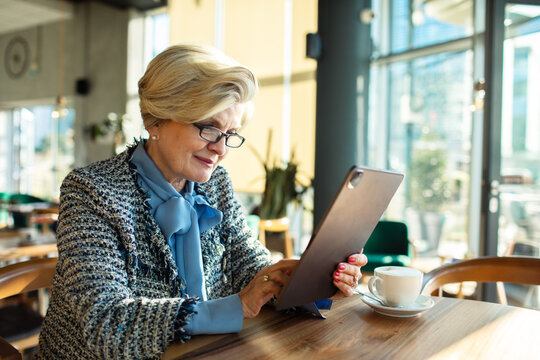 Senior woman using a tablet in a cafe
