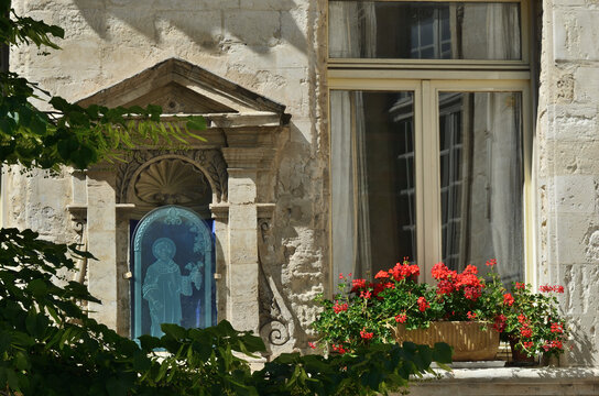 Stone wall with arched aedicule niche and window of old house. Avignon. France