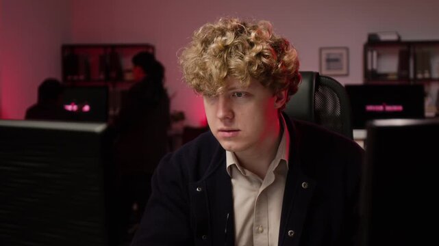 Young adult Caucasian programmer typing on keyboard and removing glasses during cyberattack on computer screen. Clip suitable for cybersecurity, software development, and tech projects