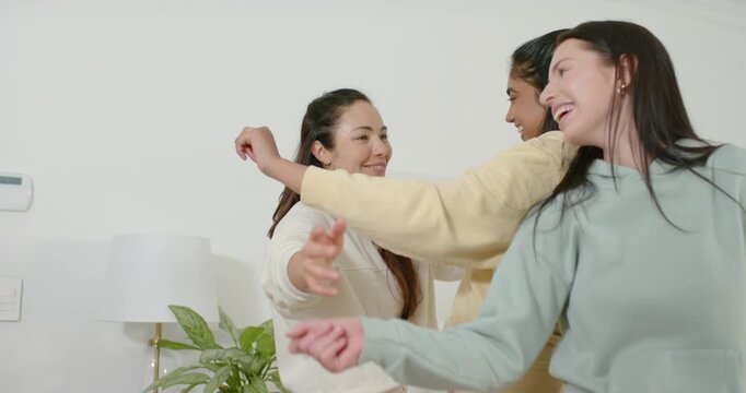 Diverse women pals following center lead moving arms in sync in bedroom hoodies smartwatch bonding