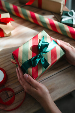 Preparing Christmas presents with colorful wrapping paper and ribbons