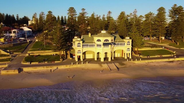 Aerial view of the historic Indiana Tea House at Cottesloe Beach, featuring its iconic arches and surrounding parkland along the coastline in Western Australia, Australia.