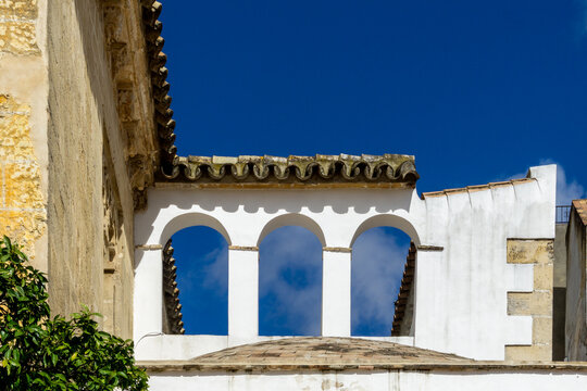 Alcazar displaying traditional Moorish architectural arches and details against a vibrant blue sky, highlighting a historic landmark in Jerez de la Frontera, Spain