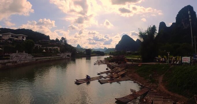 Yangshuo River Landscape with Traditional Bamboo Rafts and Karst Mountains at Sunset in Guangxi, China