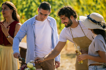 Naklejka premium Friends preparing ingredients for an outdoor meal in a vineyard