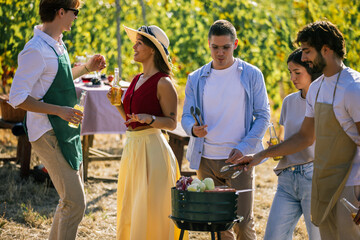 Naklejka premium Friends preparing food and drinks together during a vineyard gathering