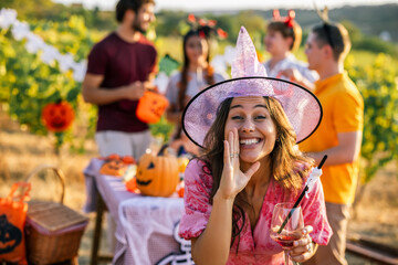 Naklejka premium Woman in witch hat enjoying a festive Halloween celebration outdoors