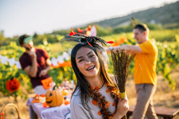 Naklejka premium Smiling woman in Halloween costume celebrating outdoors with friends