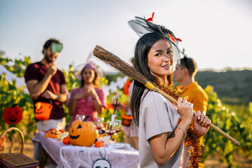 Naklejka premium Woman smiling with a Halloween broom at an outdoor vineyard celebration