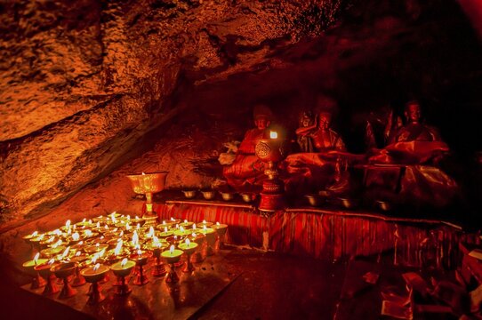 Cave with candles and Buddha images along the Kailash Kora, Western Tibet, Asia;