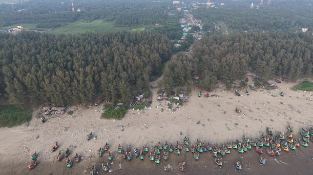Aerial view of Shamlapur Beach with dense pine forest and numerous fishing boats along the sandy coastline in Cox's Bazar, Chittagong Division, Bangladesh.