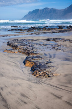 The wild and dramatic Atlantic surf and and long sandy beach at Famera in the Canaries Island of Lanzarote