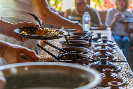 View of visitors and traditional curry dishes at Hiriwadunna Village, Anuradhapura, Sri Lanka