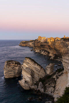 Dawn on limestone sea stacks that frame the ancient village of Bonifacio built on top of a cliff, south of Corsica (Corse-Du-Sud), Corsica, Mediterranean Sea, France