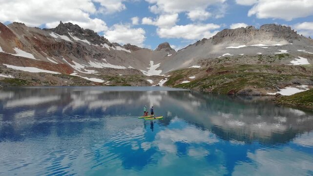 Paddle boarders with dog on a high alpine lake in Colorado