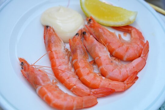 Plate of shell-on shrimp with mayonnaise and lemon