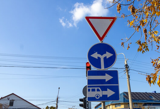Traffic signs showing directions in a city on a sunny day