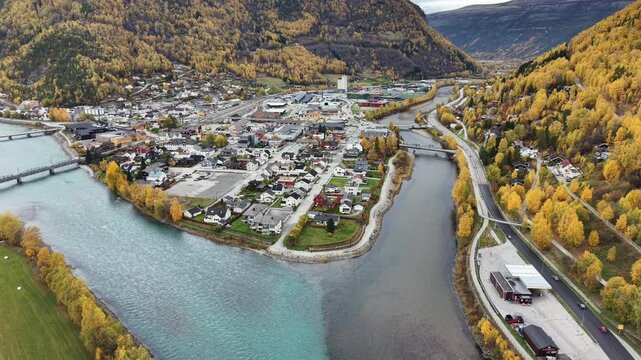 Aerial top down view of the confluence of Otta and Gudbrandsdalsl&aring;gen rivers in Otta town, Norway, showing turquoise glacial water mixing with dark river stream in autumn.