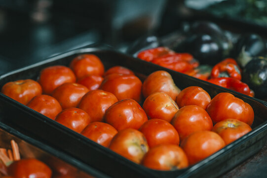 View of fresh red tomatoes arranged in a black plastic tray at a local market in Puerto Viejo de Talamanca, Limon Province, Costa Rica.