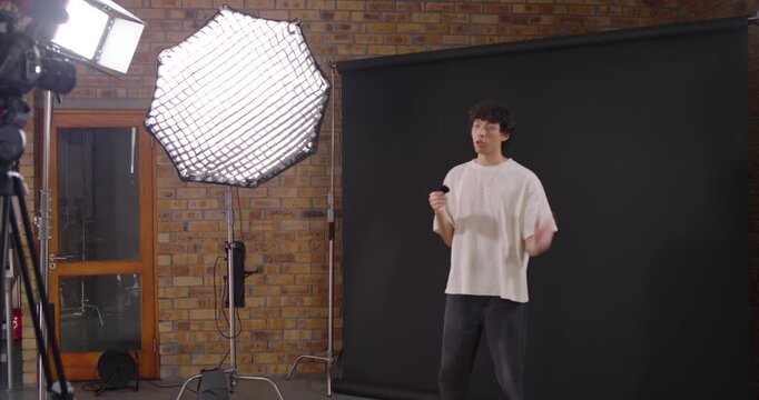 Crew snapping clapper, marking take, Asian presenter stepping into frame and speaking into mic
