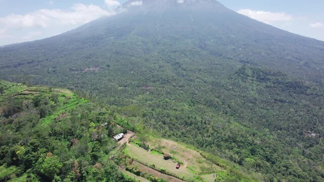 Aerial view of Bukit Cemara with lush green hills, tropical vegetation, and mountain slopes in Bebandem, Bali, Indonesia.
