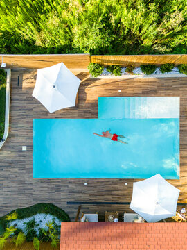 Top-Down Shot of Man Swimming in High-End Villa Pool. Concept of serene lifestyle and upscale comfort