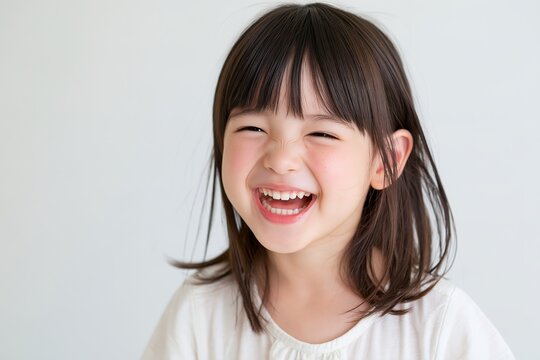 白い背景に屈託のない笑顔で笑う元気な女の子