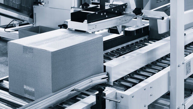 Elements of corton boxes collected in stack. Conveyor line for production of boxes. Machine cuts cardboard boxes from sheets of cardboard. Enterprise for production package.