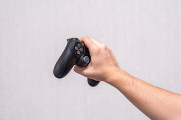 Hand holding a black game controller. This minimalist image is perfect for gaming blogs, technology reviews, and e-sports marketing materials. © ismailgazel