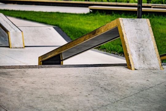 Empty concrete skate park ramp and grind rail in outdoor city park