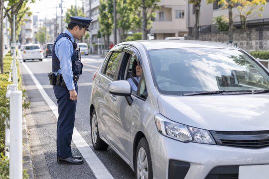 車の運転手に対応する警察官