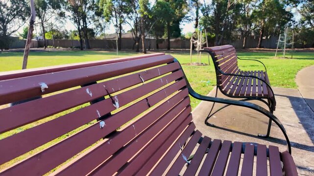 Benches in a suburban public park covered in bird droppings in Australia. Municipal park maintenance and hygiene issues, avian pest control, urban wildlife impact concepts