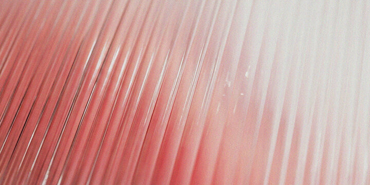 Closeup of a textured red metallic surface with parallel diagonal ridges and grooves