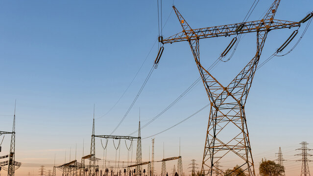 Energy grid infrastructure with high voltage pylons.