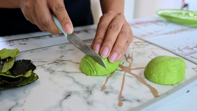 Chef hands slicing fresh green avocado fruit