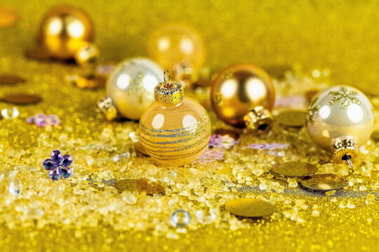 Pallina di natale dorata in primo piano su sfondo dorato