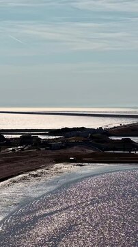 Aerial view of the Windpark Fryslan wind turbines and the Afsluitdijk causeway stretching across the water in Breezanddijk, Friesland, Netherlands.
