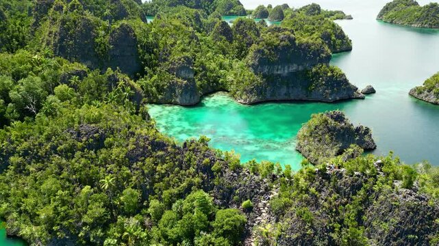 Aerial view of lush green karst islands and turquoise waters at Piaynemo in Raja Ampat, Southwest Papua, Indonesia.