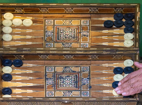 View of a traditional wooden backgammon board with intricate mother-of-pearl inlay and checkers being played in the Old City, Jerusalem, Jerusalem District, Israel.