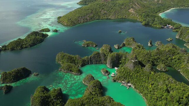 Aerial view of Piaynemo karst islands surrounded by turquoise lagoons and lush tropical greenery in Raja Ampat, Southwest Papua, Indonesia.